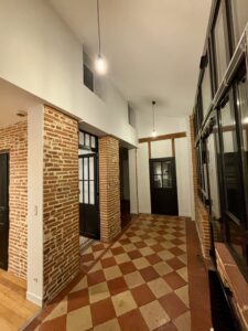 Rénovation d’un hangar agricole avec restauration d’un mur en brique, travaux de peinture et pose de carrelage